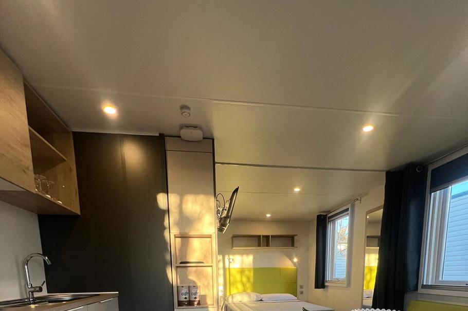 Moderno monolocale con cucina, tavolo da pranzo e letto matrimoniale.
